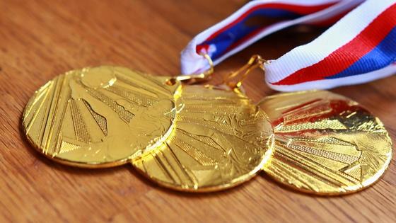 Золотые олимпийские медали лежат на столе Золотые олимпийские медали лежат на столе