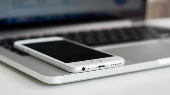 Смартфон лежит на ноутбуке Смартфон лежит на ноутбуке