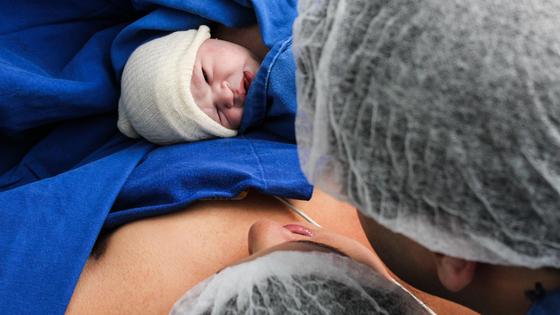 Мама и папа смотрят на новорожденного ребенка Мама и папа смотрят на новорожденного ребенка