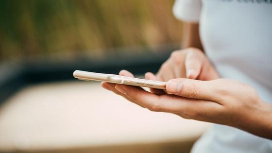 Девушка держит в руках телефон Девушка держит в руках телефон