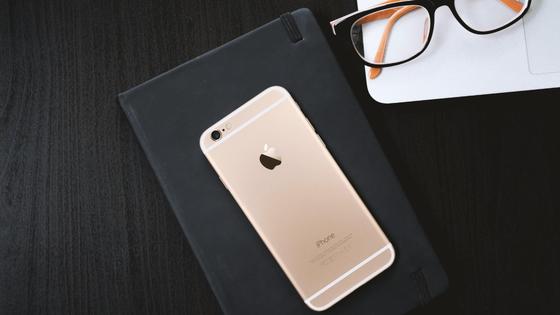 Смартфон на записной книге возле очков Смартфон на записной книге возле очков