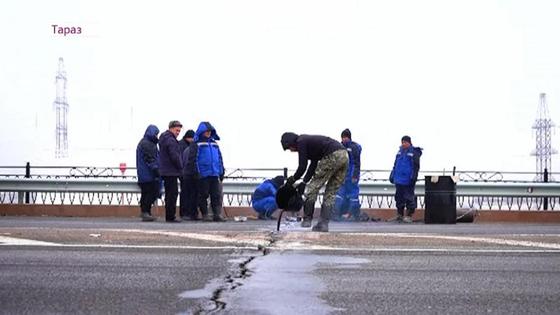 Люди стоят на мосту с трещиной Люди стоят на мосту с трещиной