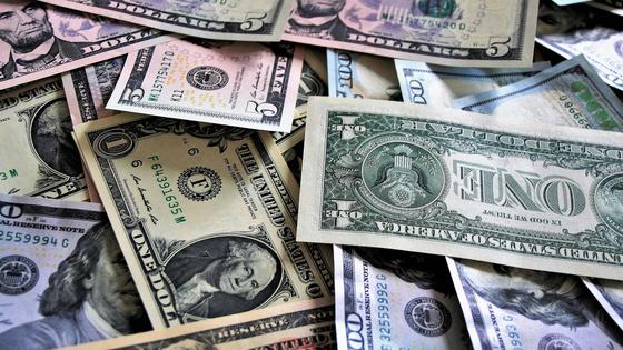 Долларовые купюры хаотично разложены на поверхности Долларовые купюры хаотично разложены на поверхности