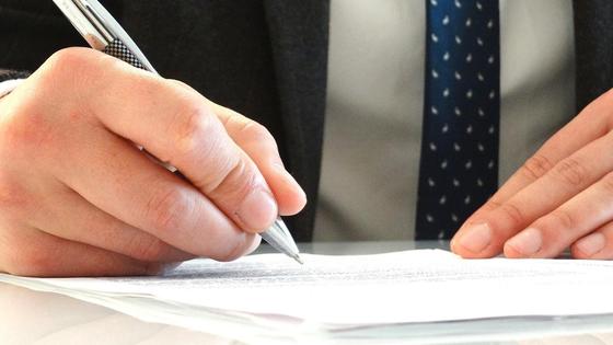 Мужчина подписывает документы Мужчина подписывает документы