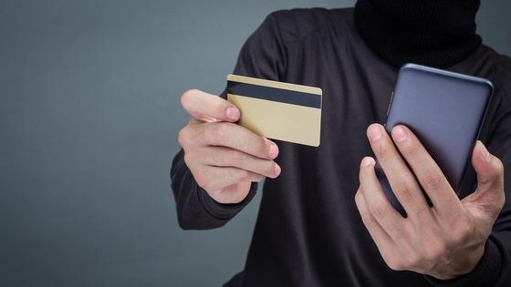 Мужчина держит смартфон и банковскую карту Мужчина держит смартфон и банковскую карту