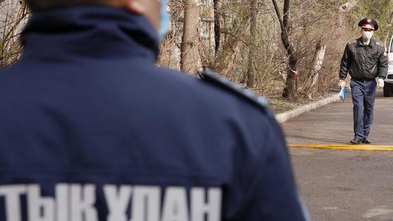 Полицейские ходят по двору оцепленной территории Полицейские ходят по двору оцепленной территории