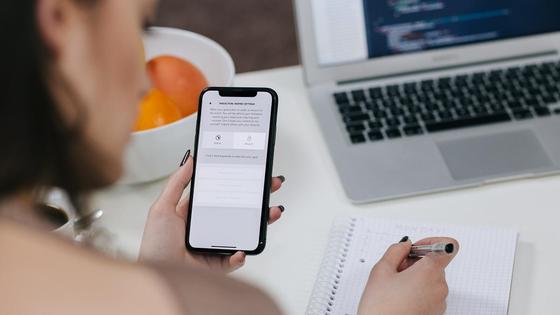 Девушка держит мобильный телефон Девушка держит мобильный телефон
