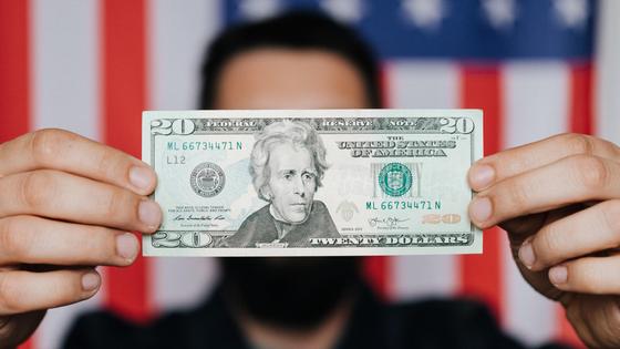 20-долларовая купюра на фоне флага США 20-долларовая купюра на фоне флага США