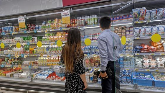 девушка и парень выбирают продукты в магазине девушка и парень выбирают продукты в магазине