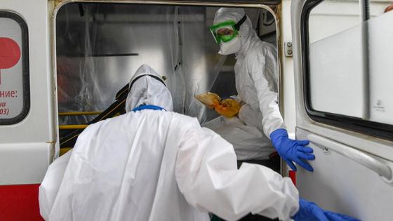 Медики заходят в машину скорой помощи Медики заходят в машину скорой помощи