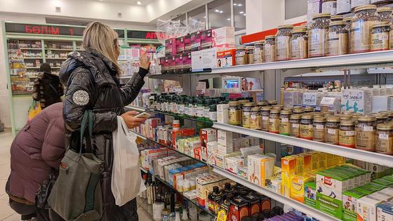 Женщина в аптеке выбирает лекарство Женщина в аптеке выбирает лекарство