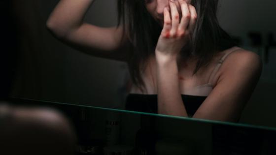 Девушка с синяками возле зеркала Девушка с синяками возле зеркала