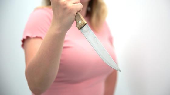 Девушка держит в руке нож Девушка держит в руке нож