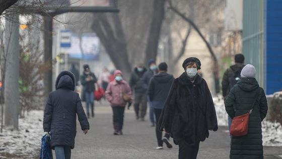 Люди в масках идут по улице Люди в масках идут по улице