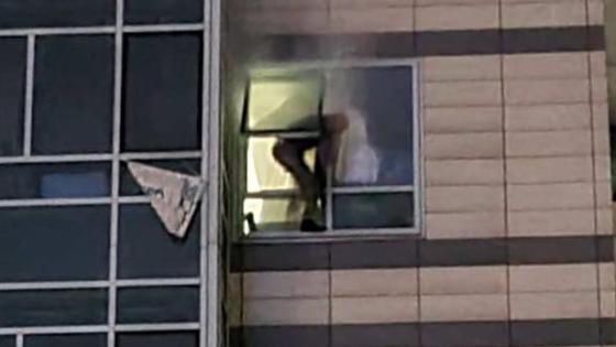 Мужчина вылезает из окна Мужчина вылезает из окна