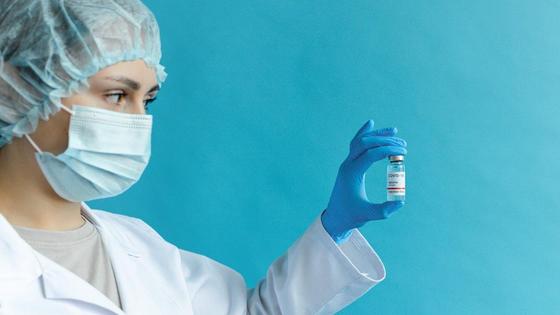 Медсестра держит вакцину в руке Медсестра держит вакцину в руке