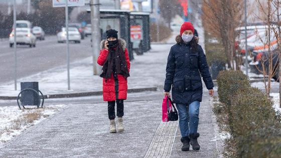 Люди в масках идут по улице Люди в масках идут по улице