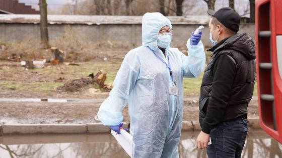 женщина в защитном костюме замеряет температуру женщина в защитном костюме замеряет температуру