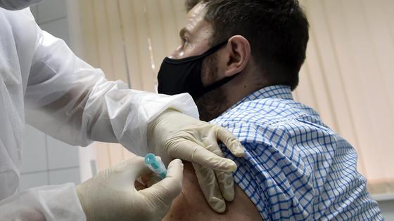 Врач ставит вакцину мужчине Врач ставит вакцину мужчине