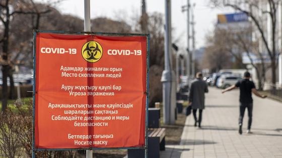 Люди в масках идут по улице Люди в масках идут по улице