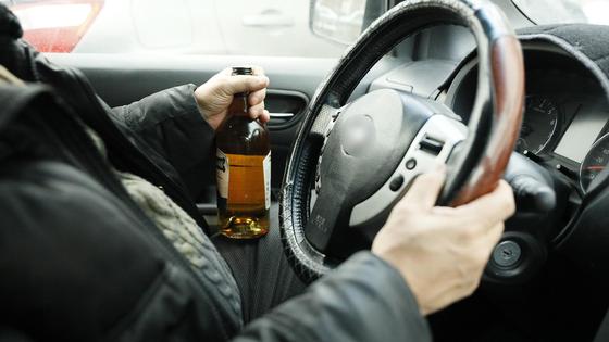Водитель держит виски за рулем Водитель держит виски за рулем