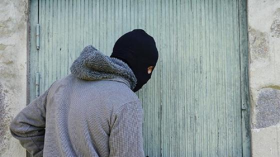 Мужчина в маске стоит возле двери Мужчина в маске стоит возле двери