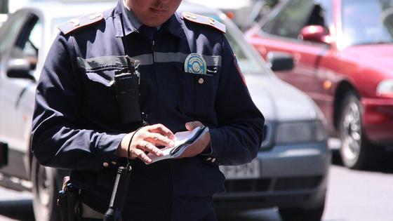 Полицейский стоит с блокнотом в руках Полицейский стоит с блокнотом в руках