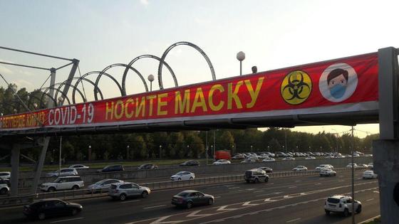 Баннер с надписью носите маску висит на дорожном мосту Баннер с надписью носите маску висит на дорожном мосту