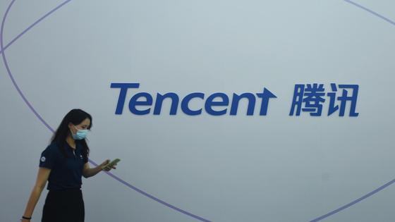 Девушка в маске на фоне логотипа Tencent Девушка в маске на фоне логотипа Tencent