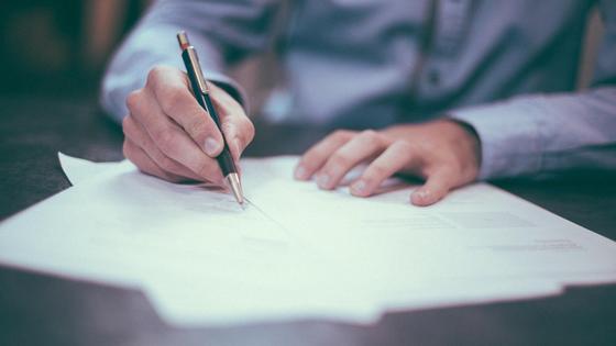 Мужчина подписывает документы Мужчина подписывает документы
