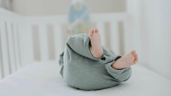 Младенец лежит в кроватке Младенец лежит в кроватке