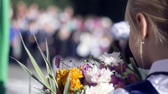 Девочка стоит на линейке с цветами Девочка стоит на линейке с цветами