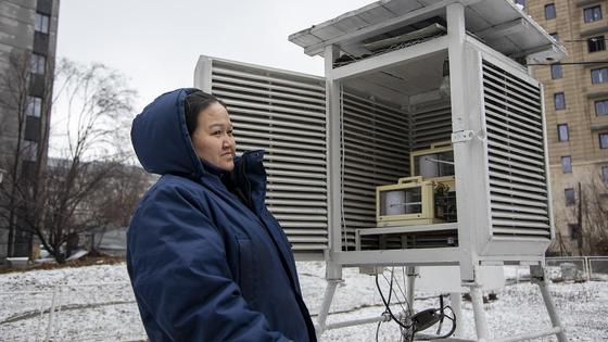 Женщина стоит около метеостанции Женщина стоит около метеостанции