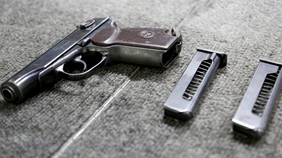 Пистолет лежит на столе Пистолет лежит на столе