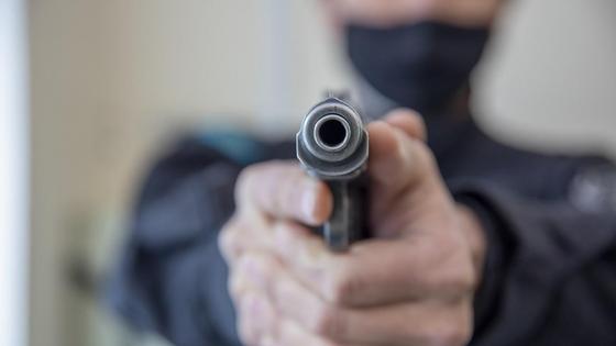 Мужчина держит в руках пистолет Мужчина держит в руках пистолет