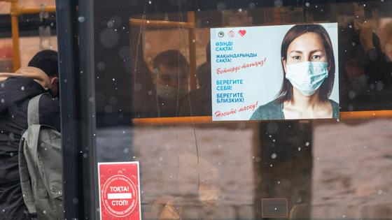 Плакат с девушкой в медмаске, размещенный на стекле автобуса Плакат с девушкой в медмаске, размещенный на стекле автобуса