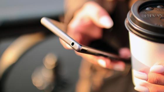 Девушка держит в руке смартфон Девушка держит в руке смартфон
