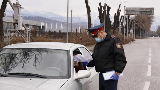 Полицейский проверяет документы у водителя авто Полицейский проверяет документы у водителя авто