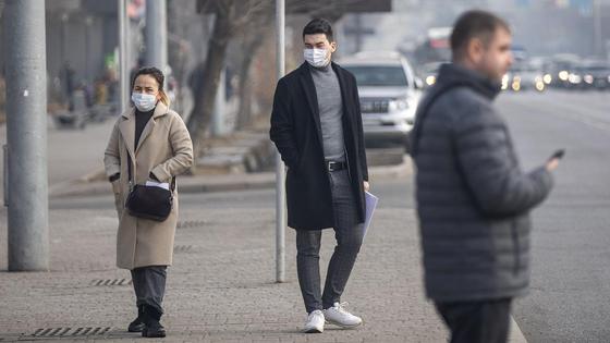 Люди в масках стоят у дороги Люди в масках стоят у дороги