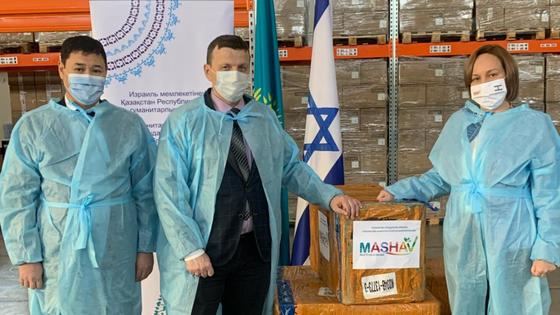 Люди в защитных костюмах стоят возле коробок Люди в защитных костюмах стоят возле коробок