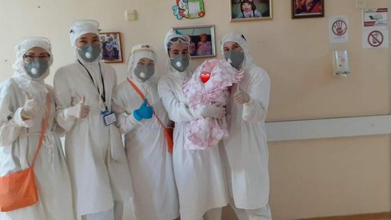 Медики стоят в палате с маленьким ребенком Медики стоят в палате с маленьким ребенком