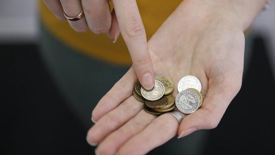 Девушка держит монеты в руках Девушка держит монеты в руках