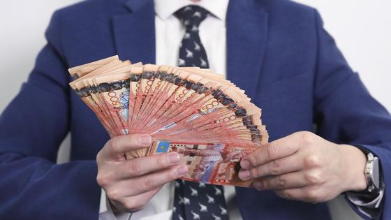 мужчина держит в руках пачку денег мужчина держит в руках пачку денег