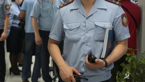 Полицейский стоит с папкой в руках Полицейский стоит с папкой в руках