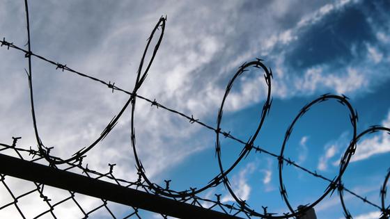 Колючая проволока натянута над забором Колючая проволока натянута над забором