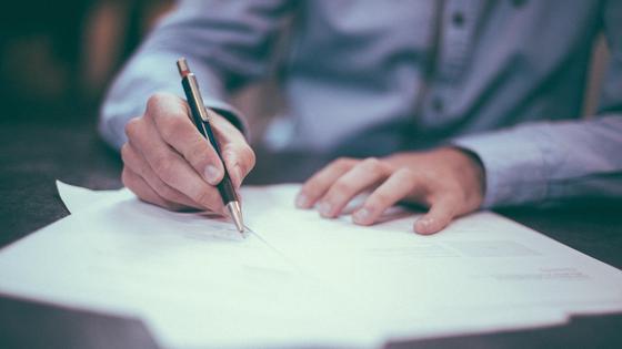 Мужчина подписывает документы Мужчина подписывает документы