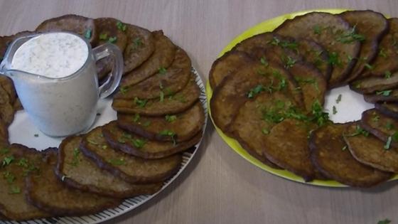 Котлеты из куриной печени на тарелках с соусом и зеленью Котлеты из куриной печени на тарелках с соусом и зеленью