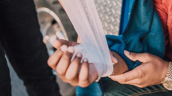 Врач перевязывает руку парню Врач перевязывает руку парню