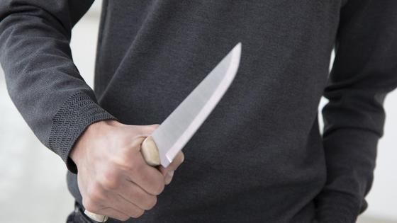 Мужчина держит в руке нож Мужчина держит в руке нож