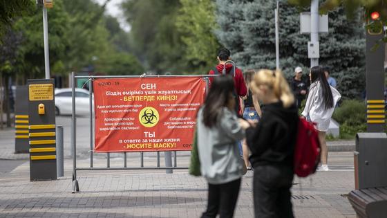 Люди в масках идут по улице Люди в масках идут по улице